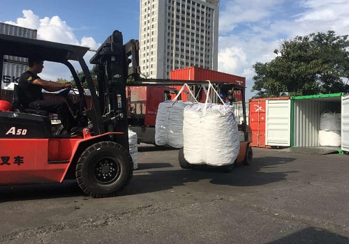 Forklift loading FeSi bags into container at Tianjin port container yard