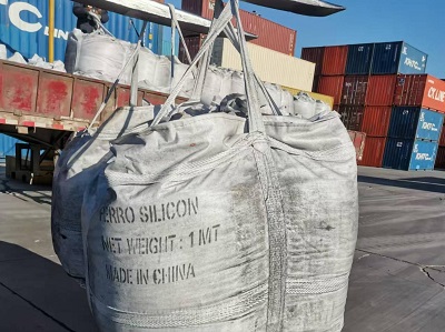 1-ton white bulk bag of ferro silicon particles being lifted by forklift at container port yard with truck unloading nearby